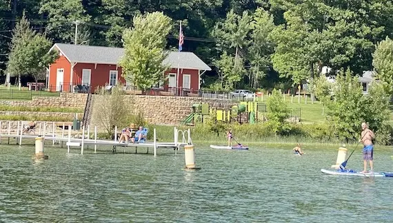Kids and adults playing in the water at a beach.