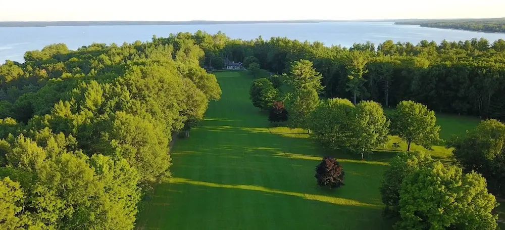 An aerial shot of Mullett Lake Country Club showing the 9th hole leading into the Clubhouse. Mullett Lake flanks the course. />
	</figure>
</div>
	</div>
</section>

		</main>
		<section class=