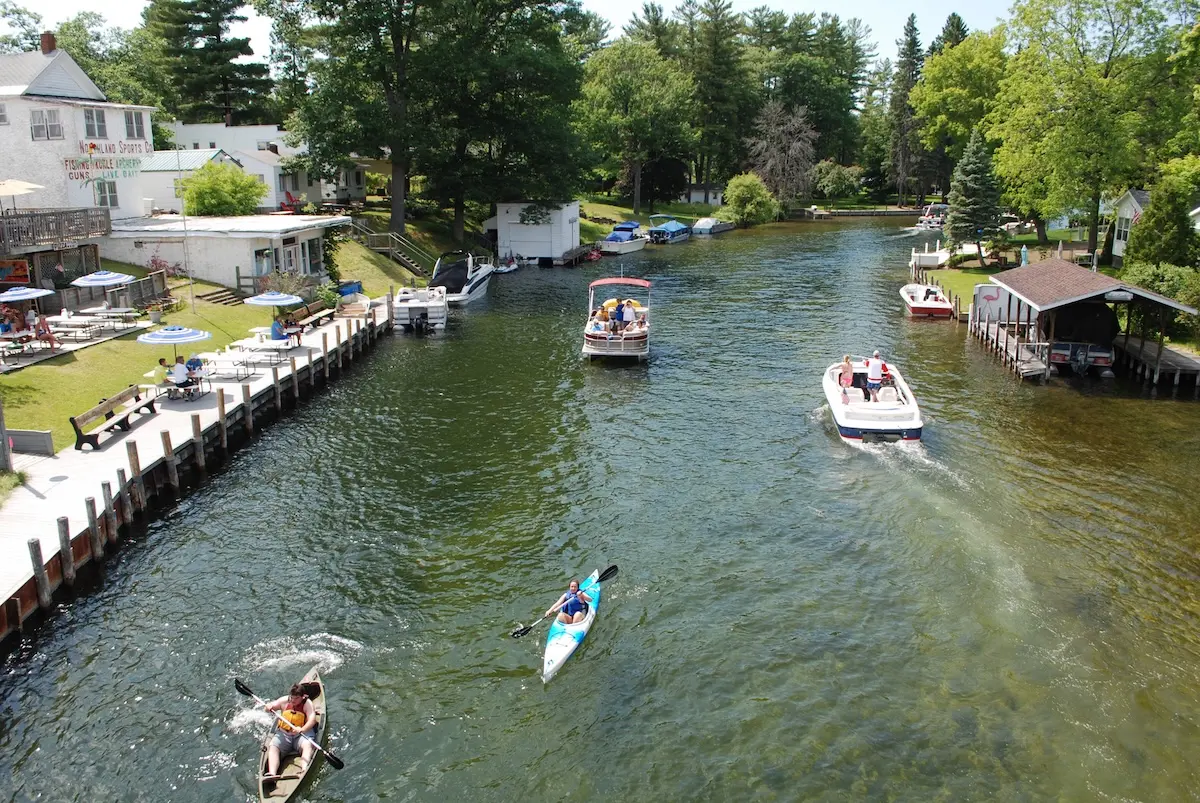 Boaters and Kayakers on the Indian River on a beautiful summer day, with diners at the Inn Between looking on.