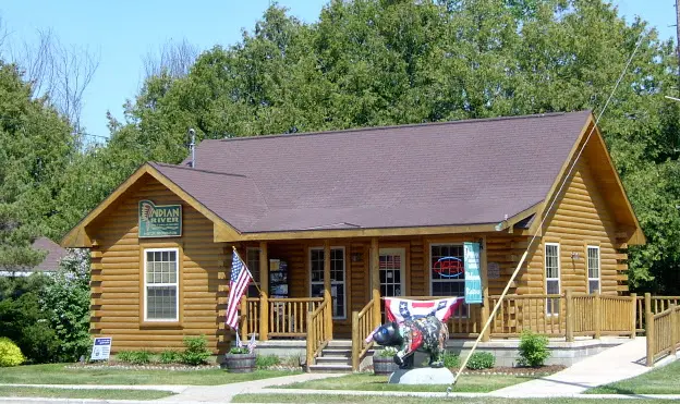 A log cabin with the Indian River Chamber logo on the outside